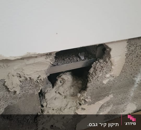 חומר גבס על קיר עם חור ותיקון